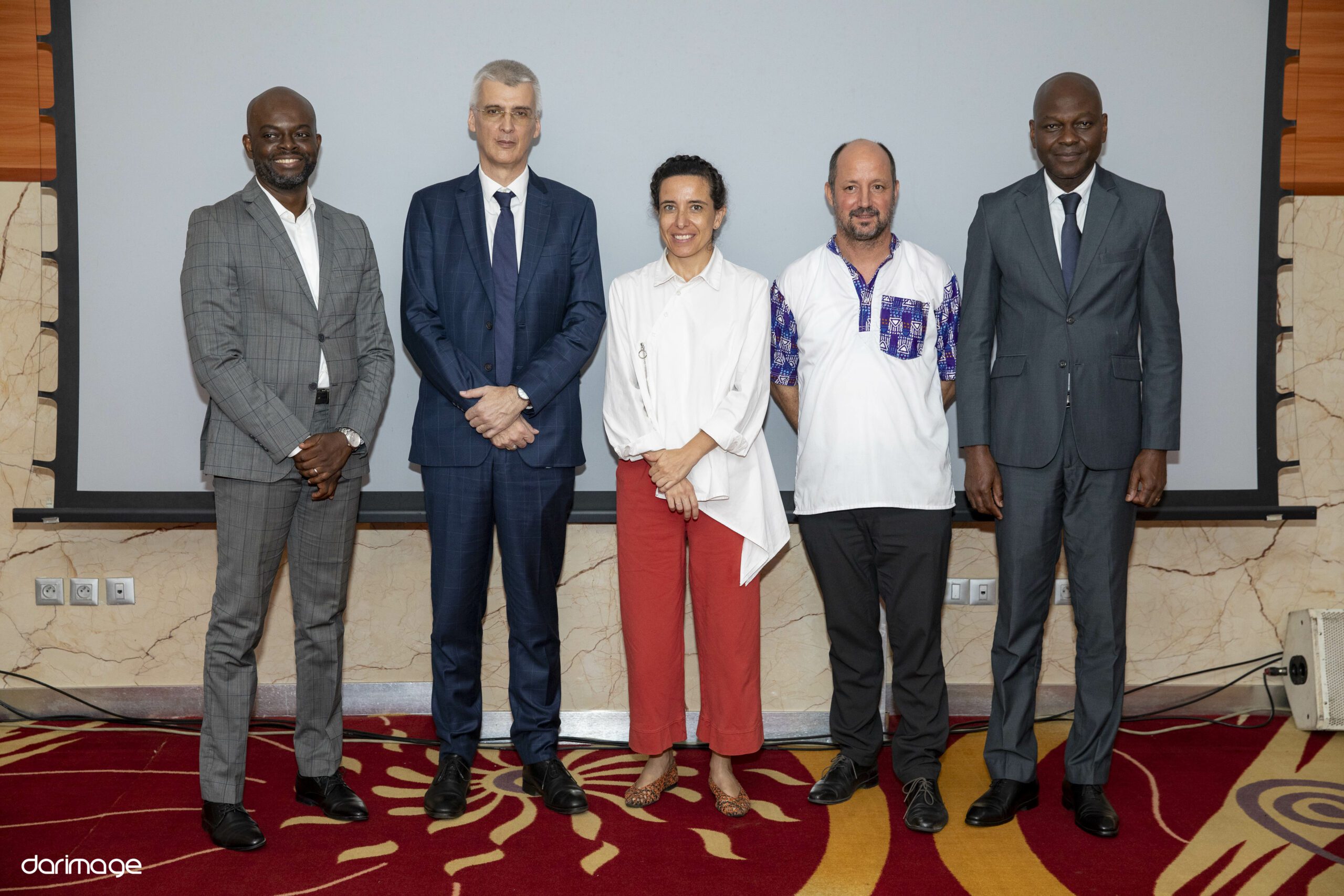Les cinq membres du jury du Demo Day national IYBA-SEED posent côte à côte devant un écran de projection